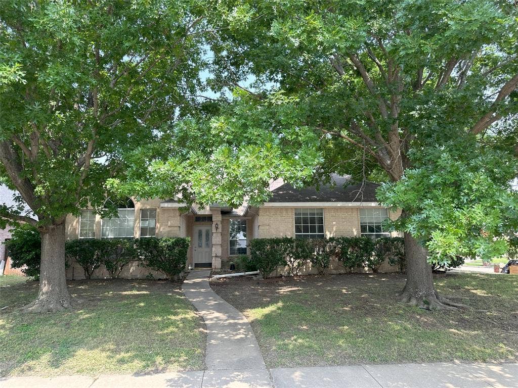 7800 Crestview Drive, Plano, TX 75024 Traditional-style exterior with a covered entry, concrete pathway, established trees, and mature landscaping