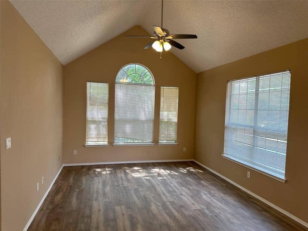 7800 Crestview Drive, Plano, TX 75024 Vaulted ceiling with a ceiling fan, wood-finish flooring, and multiple windows