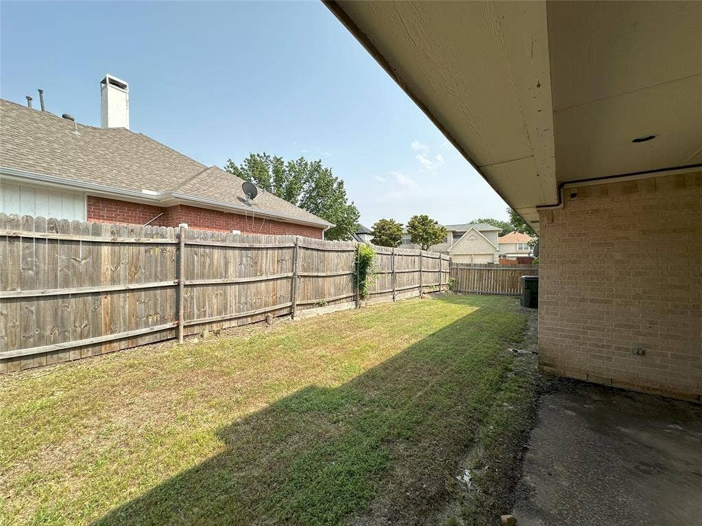 7800 Crestview Drive, Plano, TX 75024 Expansive backyard featuring a wood fence, a covered patio area, and a large grass lawn
