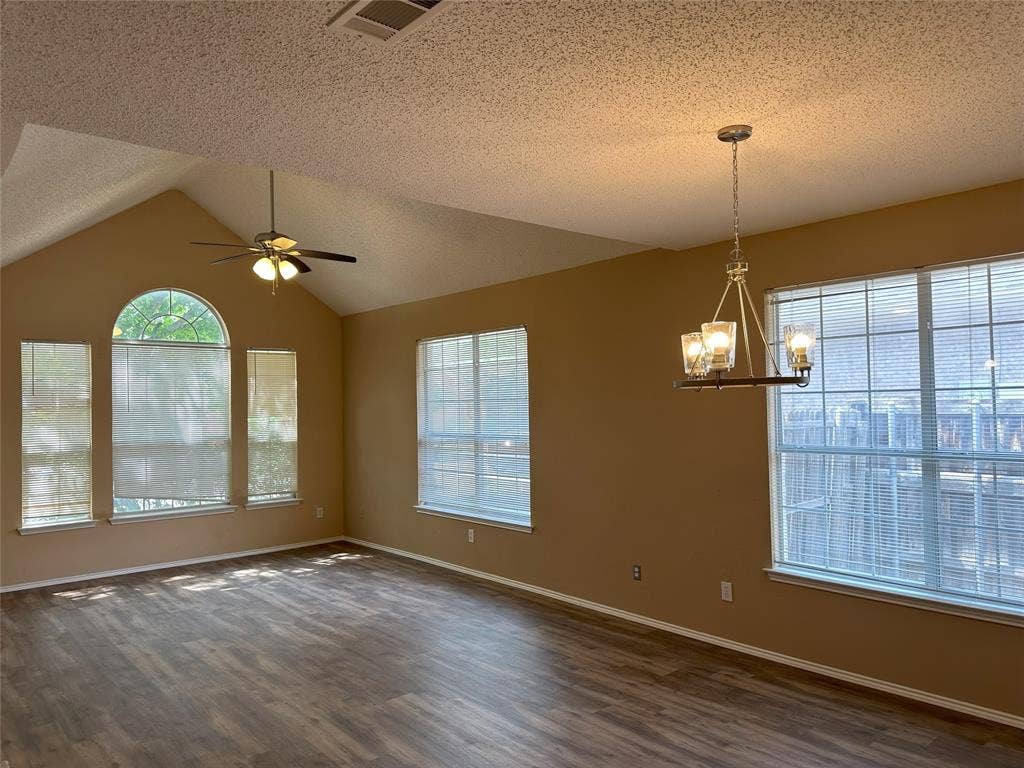 7800 Crestview Drive, Plano, TX 75024 Vaulted ceiling with a ceiling fan, wood-finish flooring, and multiple windows including an arched window