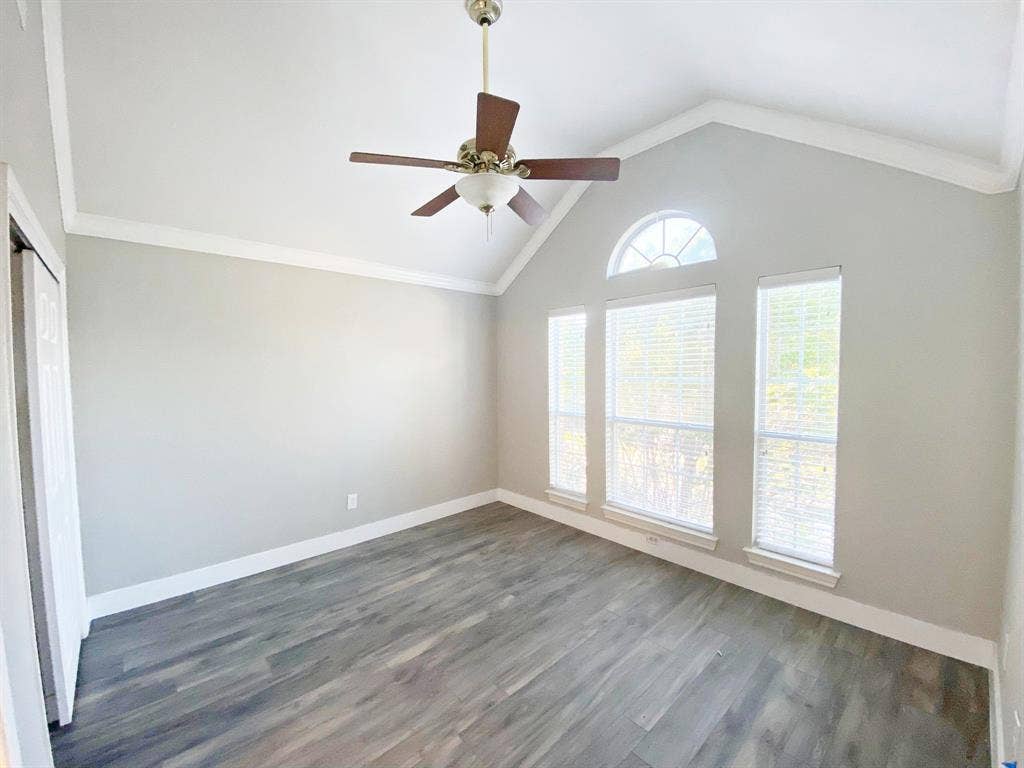 1700 Shiprock Drive, Plano, TX 75025 Empty room with crown molding, dark hardwood / wood-style flooring, ceiling fan, and lofted ceiling