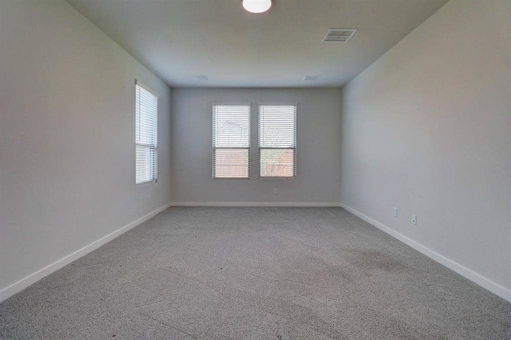 Neutral wall paint, plush carpet, recessed lighting, and multiple windows with blinds