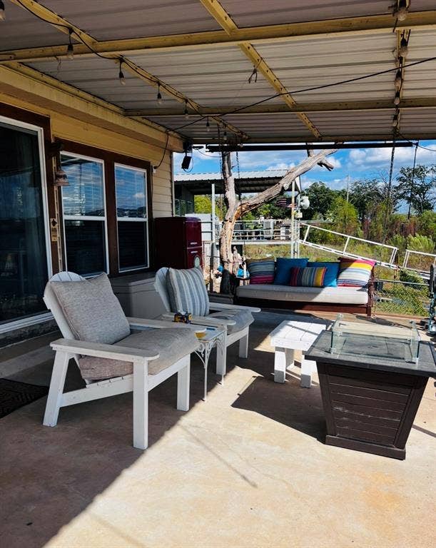 Covered patio featuring a solid roof structure and string lighting