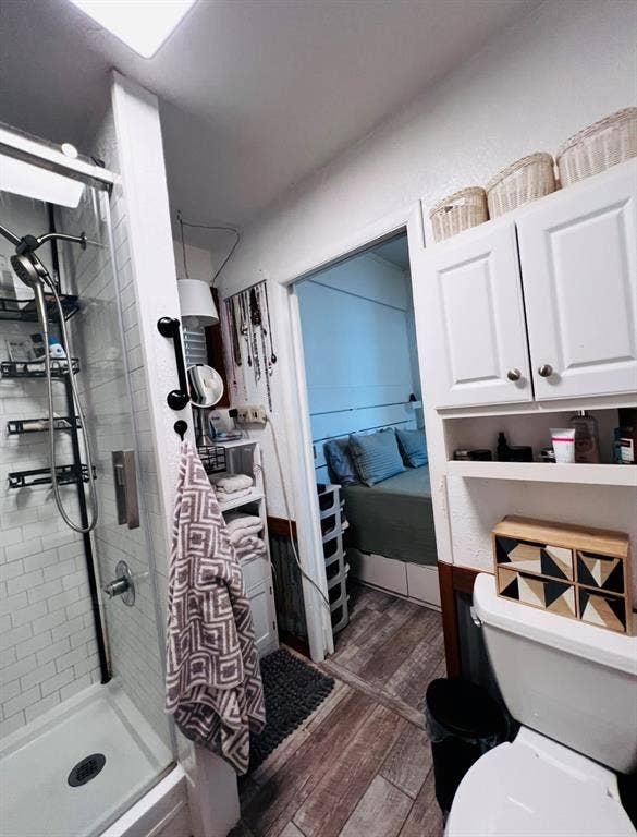 Shower with white subway tile surround, clear glass enclosure, and dark metal fixtures