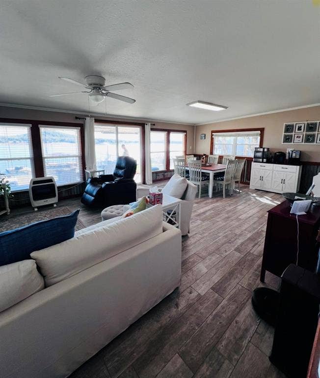 Expansive living area with wood-finish flooring, recessed lighting, and multiple windows