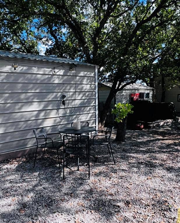 Gravel outdoor area with mature tree providing canopy