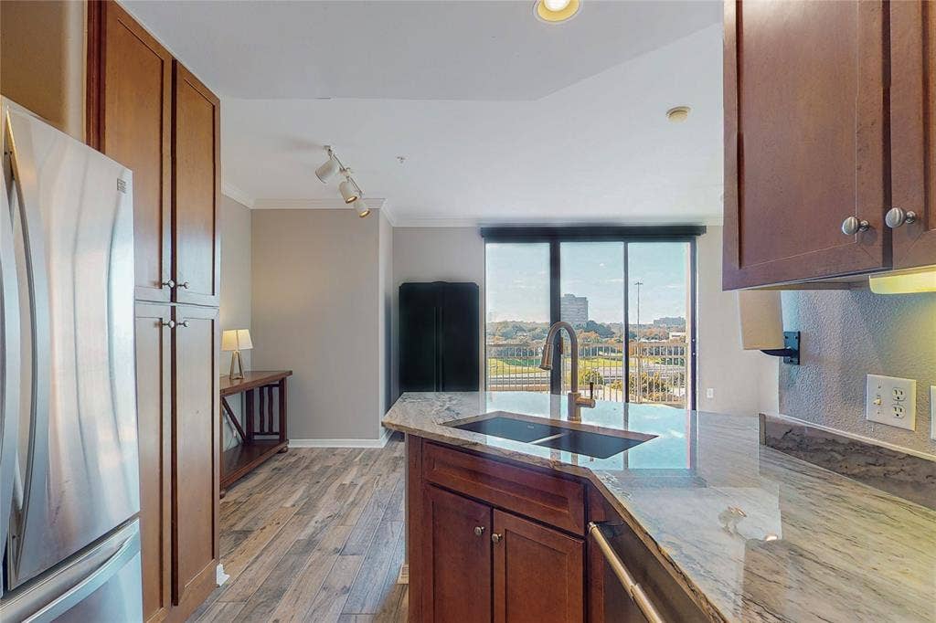 330 Las Colinas Boulevard E, #920, Irving, TX 75039 Kitchen featuring sink, ornamental molding, stainless steel appliances, light stone countertops, and light wood-type flooring