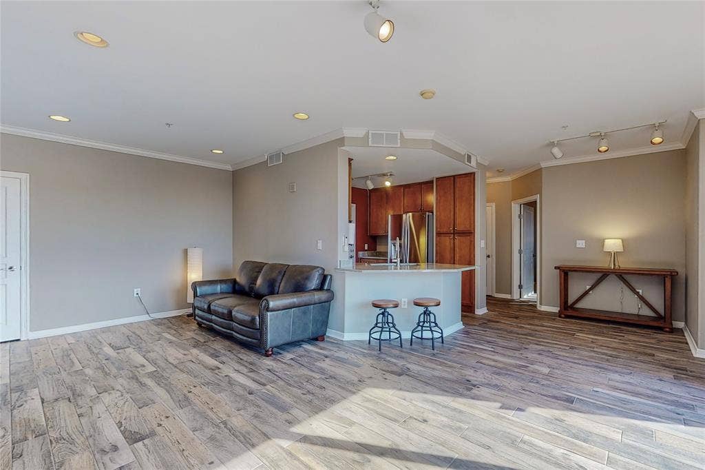 330 Las Colinas Boulevard E, #920, Irving, TX 75039 Living room with crown molding, track lighting, and light wood-type flooring