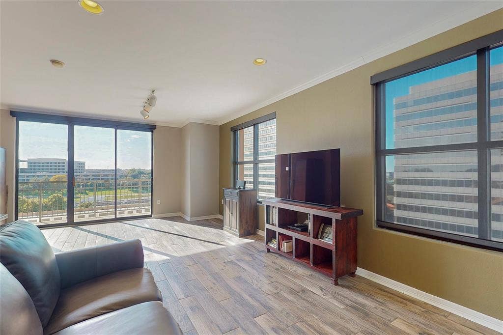 330 Las Colinas Boulevard E, #920, Irving, TX 75039 Living room featuring ornamental molding, rail lighting, a healthy amount of sunlight, and light hardwood / wood-style floors
