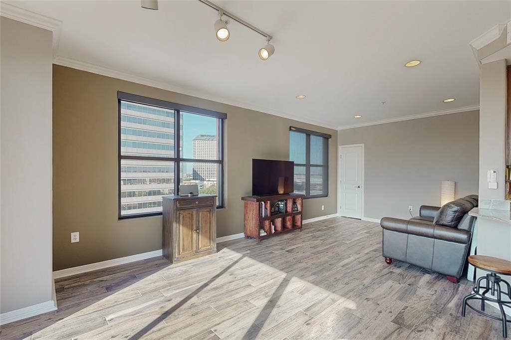 330 Las Colinas Boulevard E, #920, Irving, TX 75039 Living room featuring ornamental molding, rail lighting, and light wood-type flooring