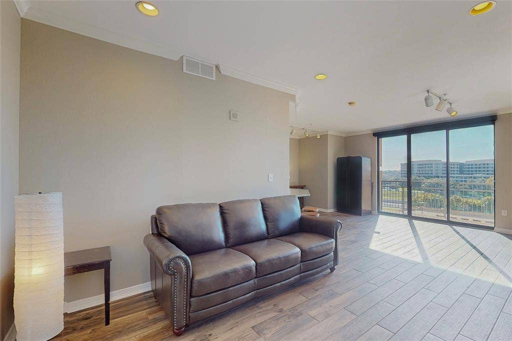 330 Las Colinas Boulevard E, #920, Irving, TX 75039 Living room featuring crown molding, rail lighting, and light wood-type flooring