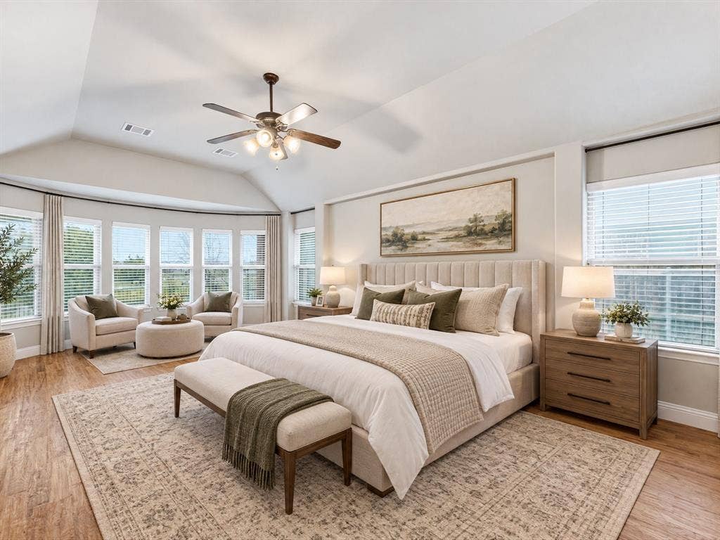 Vaulted ceilings, wood-finish flooring, bay window, and a multi-blade ceiling fan with integrated lighting