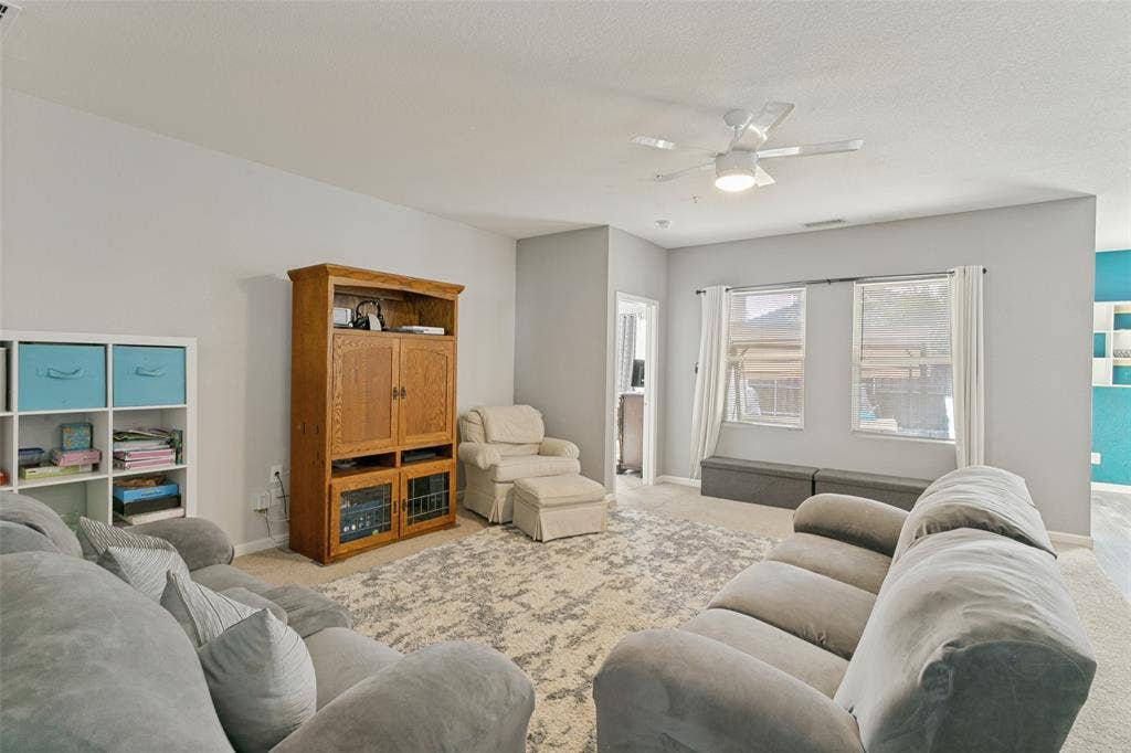 540 S Heights Drive, Crowley, TX 76036 Living area featuring neutral wall paint, carpeting, dual windows, and a ceiling fan with integrated lighting