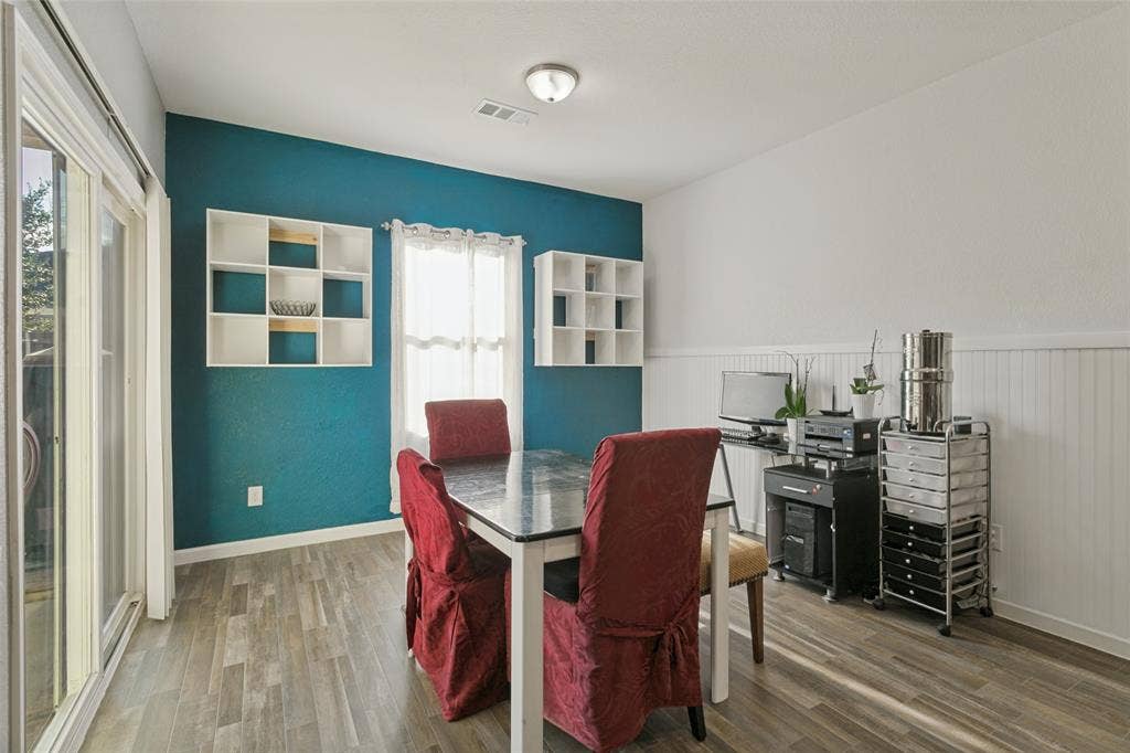 540 S Heights Drive, Crowley, TX 76036 Wood-finish flooring, dual built-in wall shelving units, sliding glass door, and white wainscoting