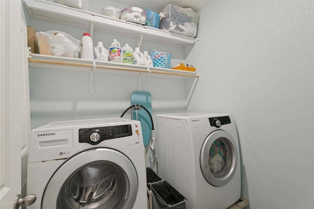 540 S Heights Drive, Crowley, TX 76036 Utility area featuring two levels of wall-mounted open shelving and a dedicated space for laundry appliances
