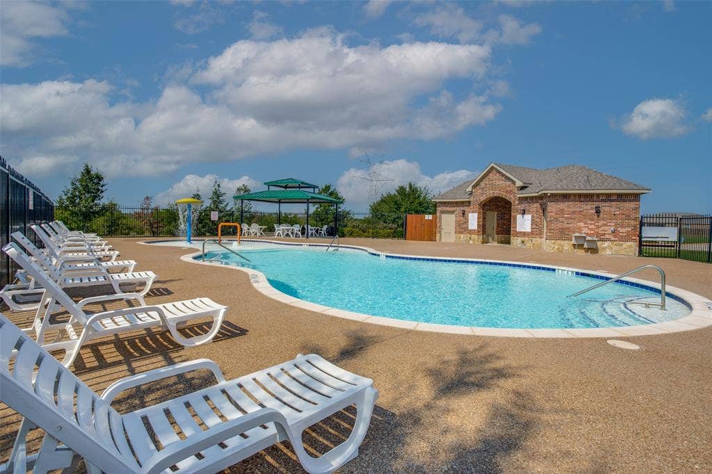 540 S Heights Drive, Crowley, TX 76036 Swimming pool with an integrated water feature, sprawling concrete deck, covered gazebo, and a brick clubhouse