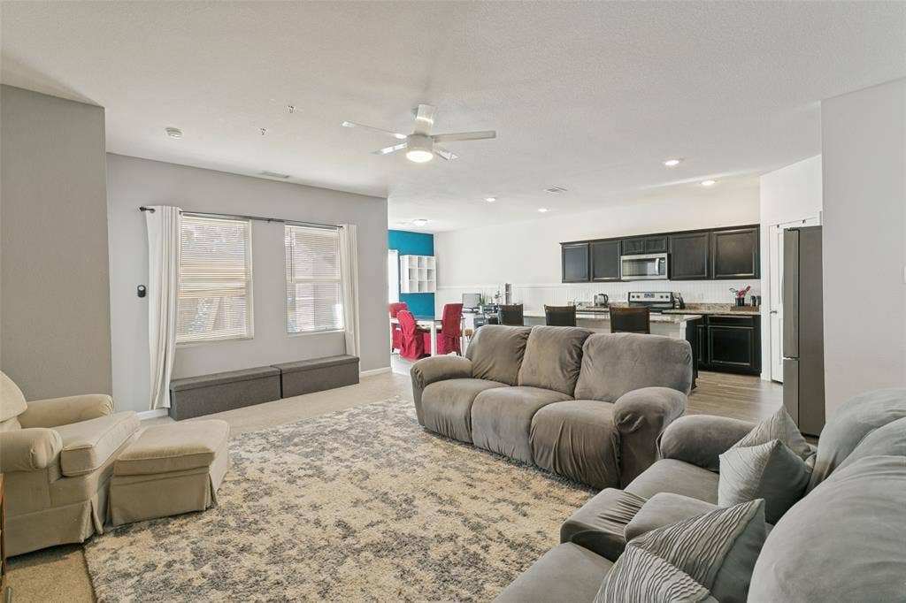 540 S Heights Drive, Crowley, TX 76036 Open-concept floor plan featuring recessed lighting, a ceiling fan, and a kitchen equipped with dark cabinetry, a breakfast bar, and stainless steel appliances