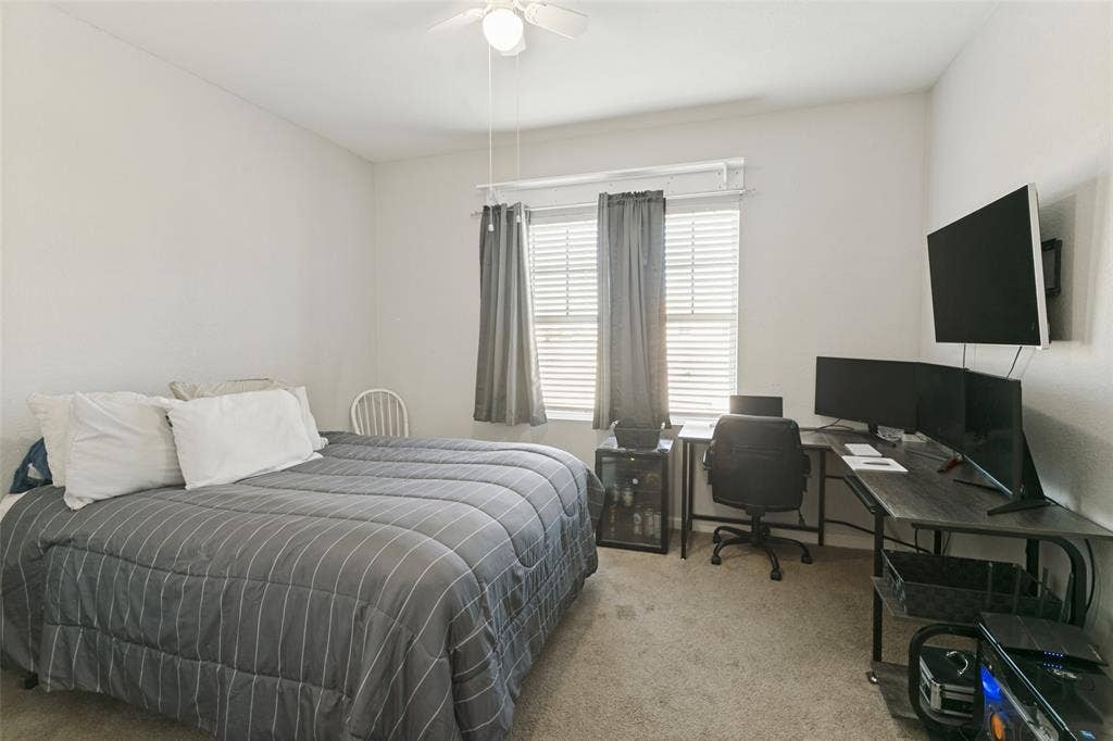 540 S Heights Drive, Crowley, TX 76036 Neutral-toned room featuring wall-to-wall carpeting, a central ceiling fan with integrated lighting, and a multi-pane window