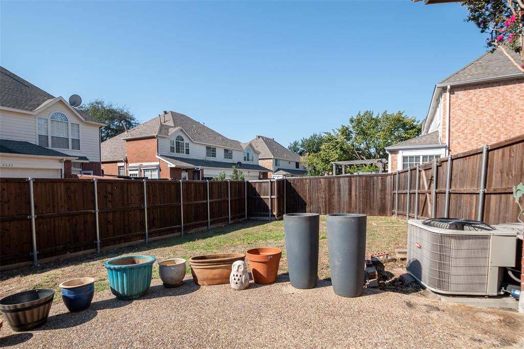 Expansive fenced yard with a combination of grass and gravel areas