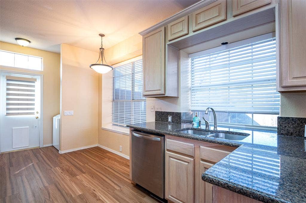 Kitchen featuring wood-finish flooring, granite countertops, and light-toned cabinetry