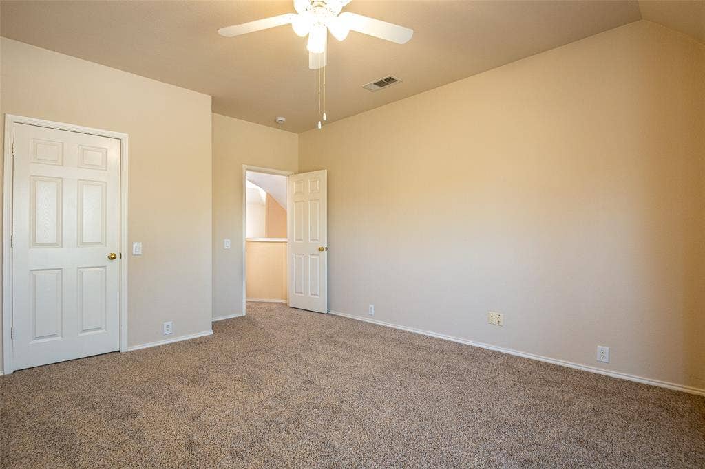 Neutral carpeted flooring, light-toned wall paint, and a ceiling fan with integrated lighting