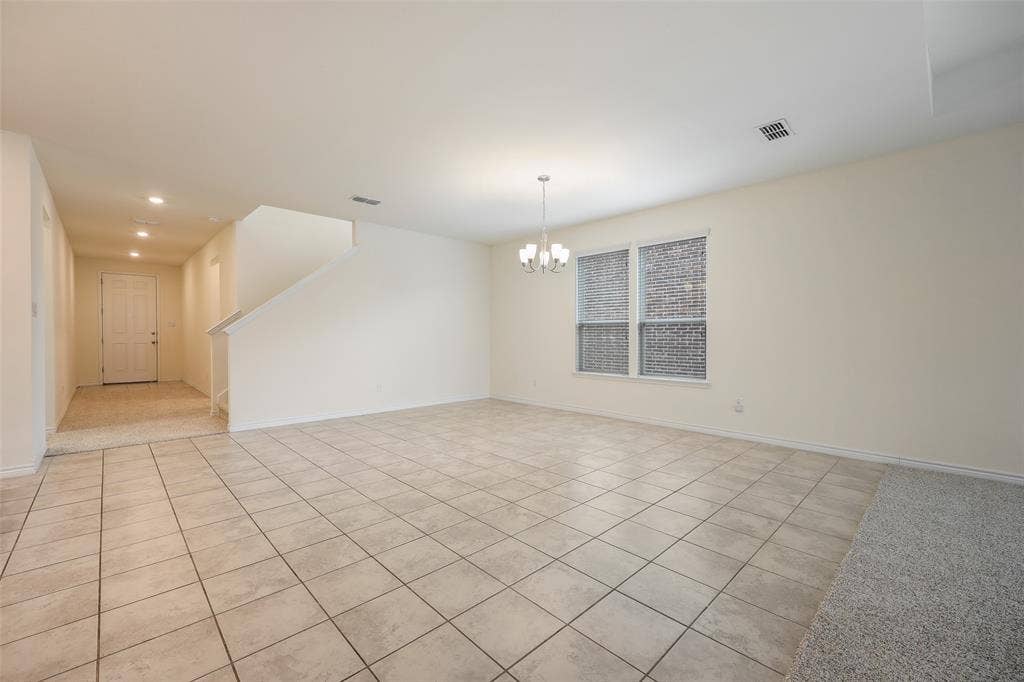 3681 Keechi Creek Drive, Celina, TX 75078 Open-concept interior featuring neutral wall tones, large-format ceramic tile flooring, a multi-arm chandelier, and double-paned windows