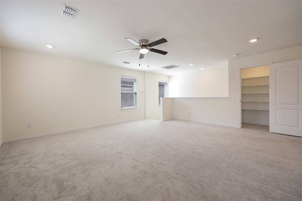 3681 Keechi Creek Drive, Celina, TX 75078 Neutral-toned interior space featuring carpeted flooring, a ceiling fan with integrated lighting, recessed lighting, and a built-in walk-in storage area with shelving