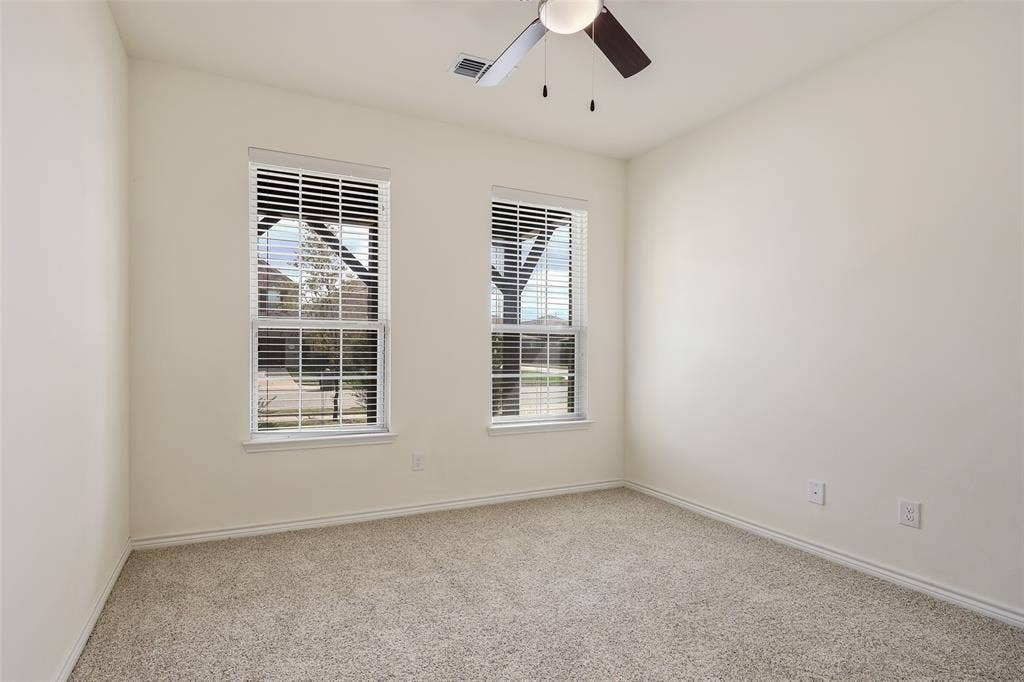 3681 Keechi Creek Drive, Celina, TX 75078 Neutral wall-to-wall carpeting, two dual-pane windows with horizontal blinds, and a ceiling fan with integrated lighting fixture