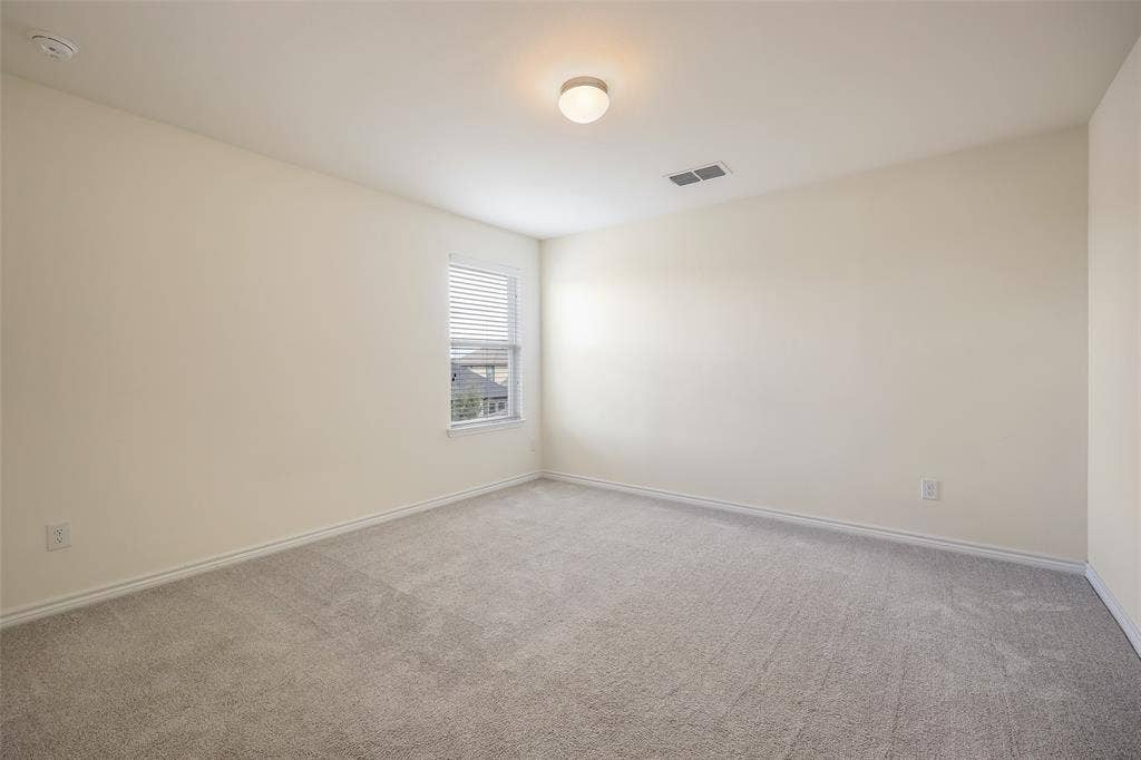 3681 Keechi Creek Drive, Celina, TX 75078 Neutral-toned room featuring neutral carpeting, a single window with blinds, and a central flush-mount ceiling light fixture