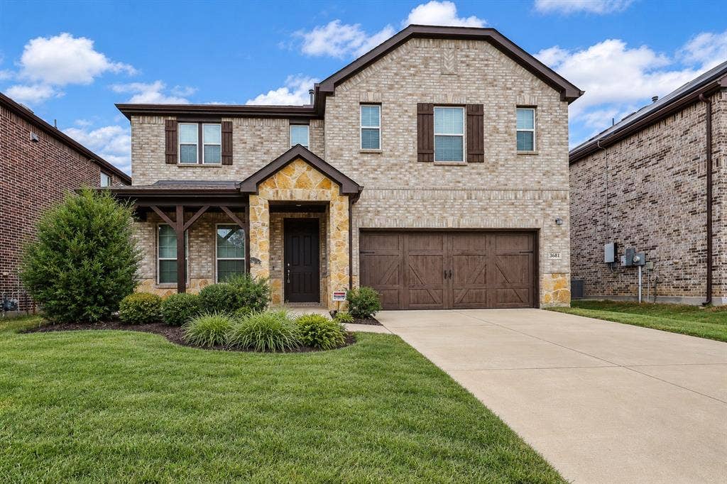 3681 Keechi Creek Drive, Celina, TX 75078 Virtually improved image. Two-story brick and stone veneer exterior featuring wood-finish decorative shutters, a covered entryway with timber-frame accents, and an attached multi-car garage with carriage-style doors