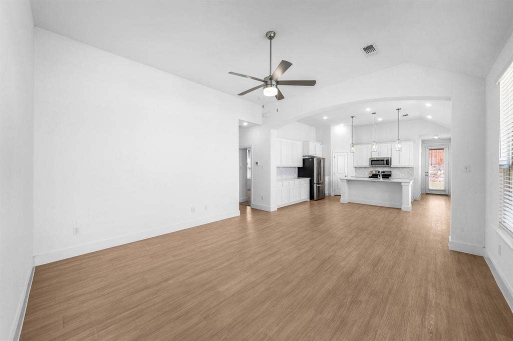 3800 Talisker Boulevard, Sherman, TX 75090 Open concept living space with vaulted ceilings, wood-finish flooring, and a ceiling fan