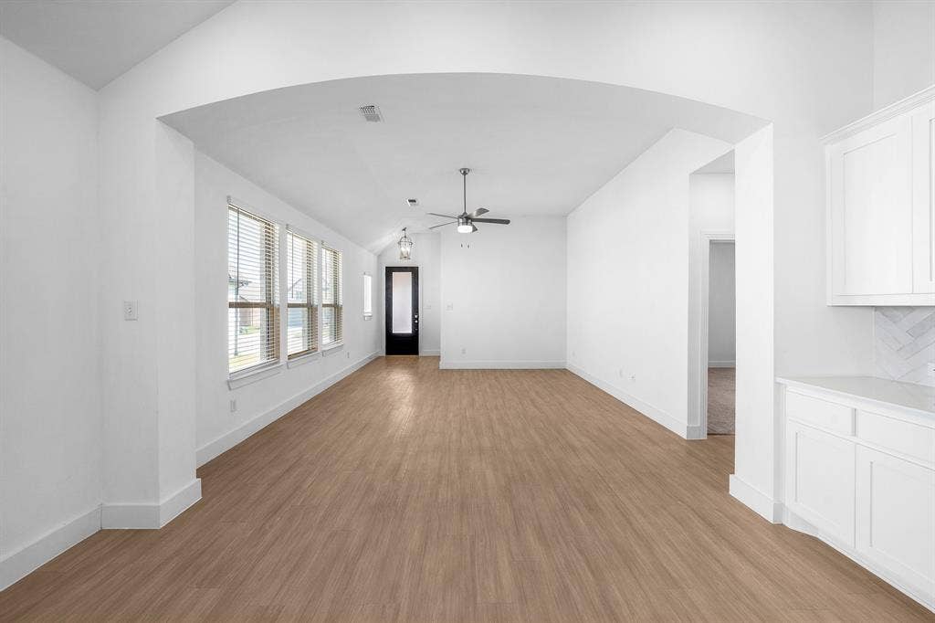 3800 Talisker Boulevard, Sherman, TX 75090 Wood-finish flooring, recessed lighting, white cabinetry with stone countertops, and a full wall of windows with blinds