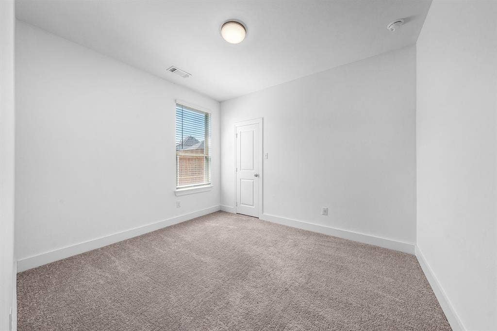 3800 Talisker Boulevard, Sherman, TX 75090 Neutral tone wall paint, carpet flooring, window with blinds, flush mount ceiling light, and interior door