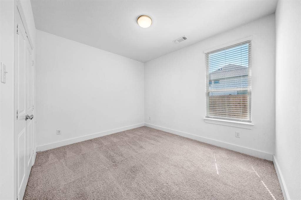 3800 Talisker Boulevard, Sherman, TX 75090 Neutral tone carpet, white painted walls, single window with blinds, ceiling-mounted light fixture, paneled door with knob