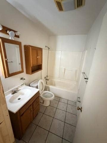 Bathroom featuring a single vanity, tiled flooring, wood-finish cabinetry, and a shower-tub combination