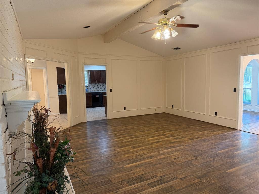 2408 Skiles Drive, Plano, TX 75075 Vaulted ceiling with exposed beam, wood-finish flooring, paneled wall detailing, and a ceiling fan with integrated lighting
