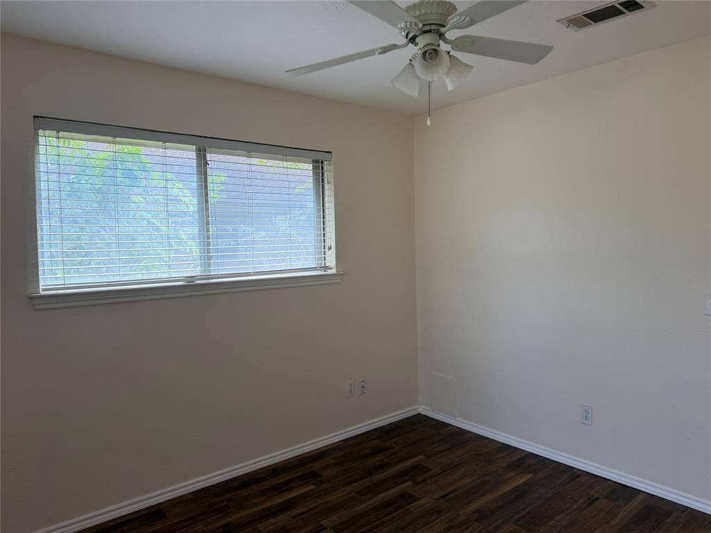 2408 Skiles Drive, Plano, TX 75075 Warm neutral wall color, wood-finish flooring, white window trim, horizontal blinds, and a ceiling fan with integrated lighting