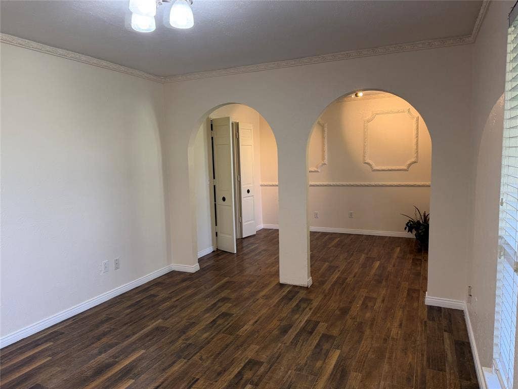 2408 Skiles Drive, Plano, TX 75075 Wood-finish flooring, arched doorways, detailed crown molding, decorative wall trim, and paneled doors
