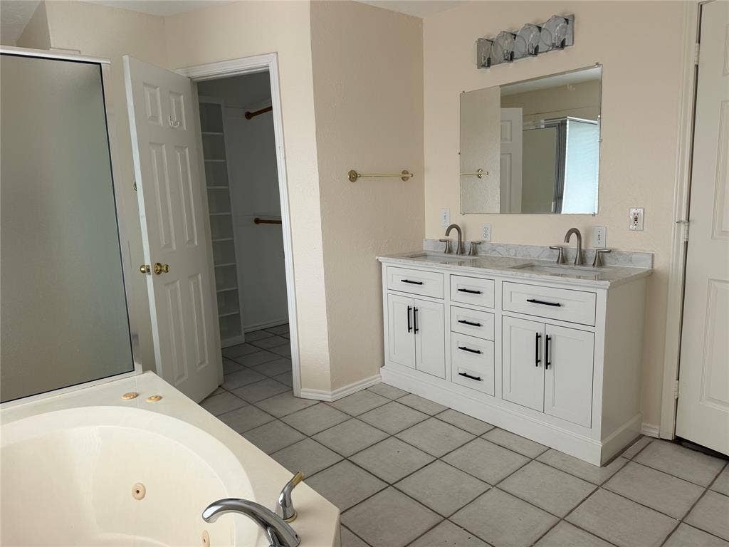 2408 Skiles Drive, Plano, TX 75075 Dual vanity with undermount sinks, a large mirror, and overhead lighting