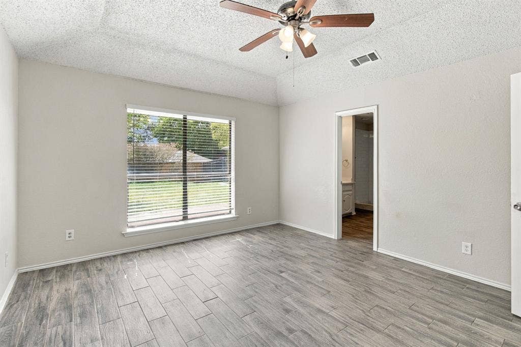 438 Blueridge Drive, Duncanville, TX 75137 Room featuring wood-finish flooring, a tray ceiling, ceiling fan with integrated lighting, and a window with horizontal blinds