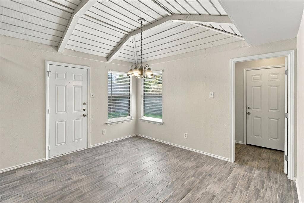 438 Blueridge Drive, Duncanville, TX 75137 Vaulted ceiling with exposed wood-finish beams, wood-finish flooring, and a multi-arm pendant light fixture