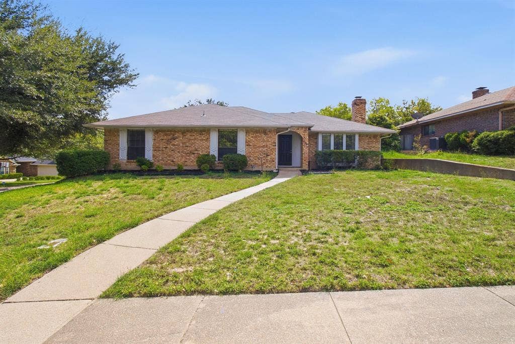 438 Blueridge Drive, Duncanville, TX 75137 Brick exterior featuring an arched entryway, masonry chimney, and concrete walkway