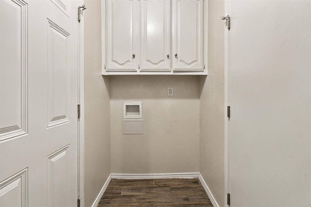 438 Blueridge Drive, Duncanville, TX 75137 Utility area featuring upper wall-mounted cabinetry, wood-finish flooring, and recessed utility hookups