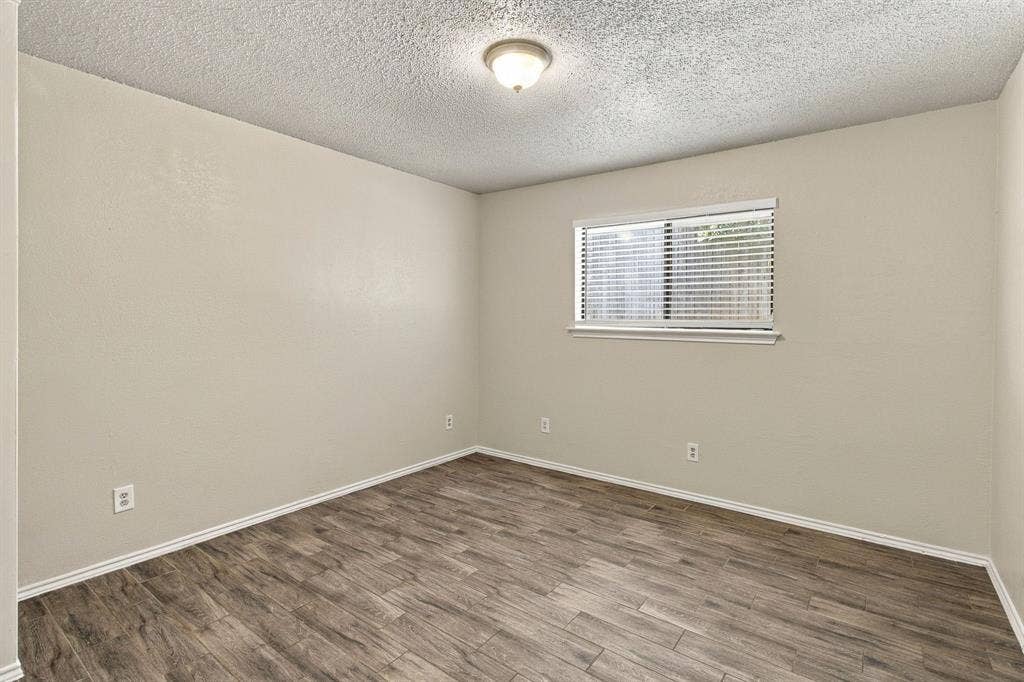 438 Blueridge Drive, Duncanville, TX 75137 Interior room featuring wood-finish flooring, neutral wall paint, and a central flush-mount ceiling light fixture with an inset window