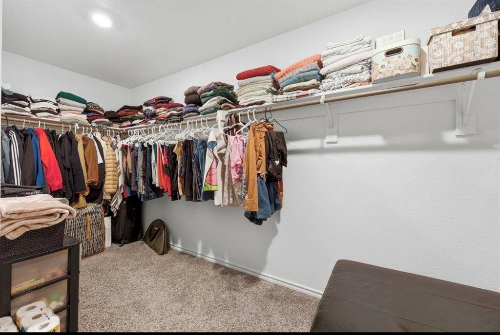 6535 Sand Dune Way, Princeton, TX 75407 Walk-in closet featuring wall-to-wall carpeting, recessed ceiling lighting, and integrated shelving with mounted garment rods