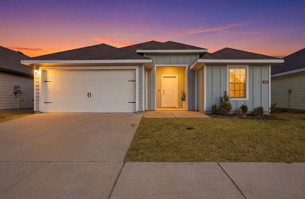 6535 Sand Dune Way, Princeton, TX 75407 Single-story residence featuring a board-and-batten exterior, a two-car garage, a covered entryway, and a concrete driveway