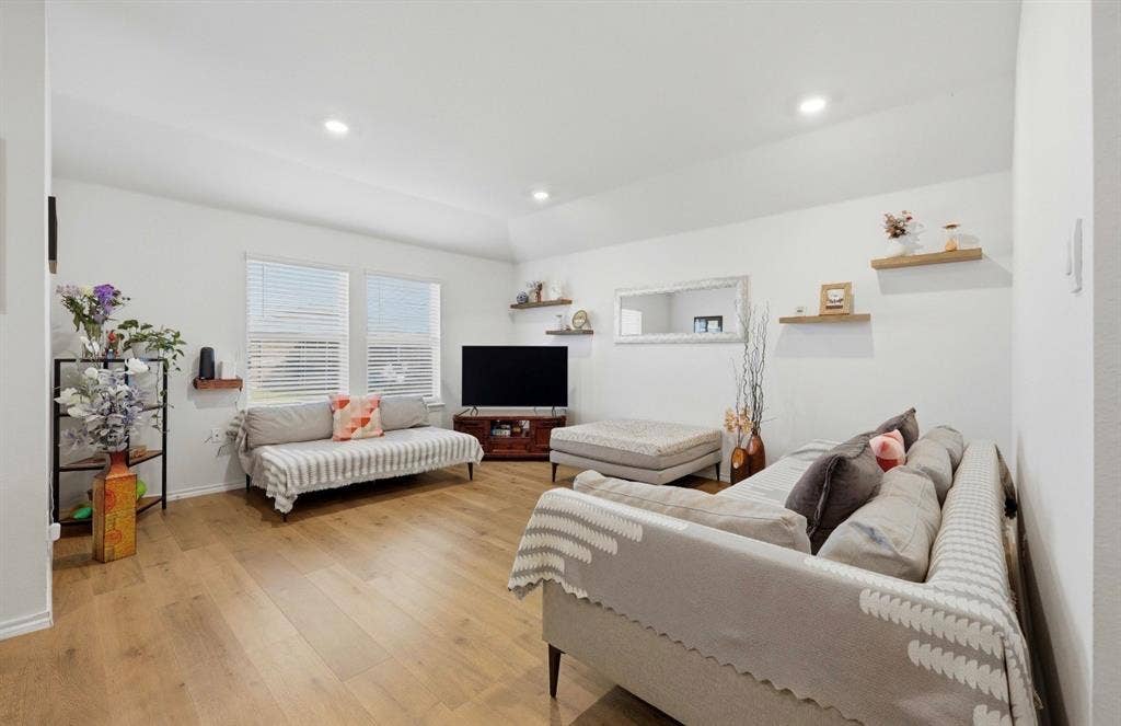 6535 Sand Dune Way, Princeton, TX 75407 Living area featuring vaulted ceilings, wood-finish flooring, recessed lighting, and wall-mounted wood floating shelving