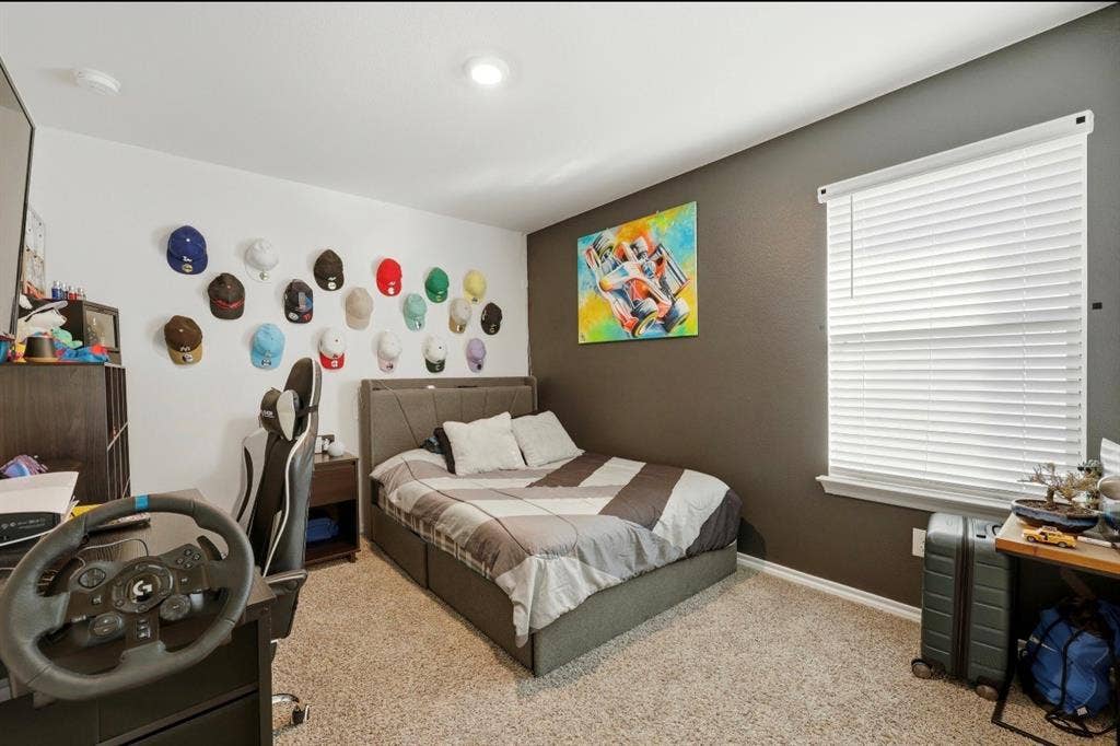 6535 Sand Dune Way, Princeton, TX 75407 Bedroom featuring neutral carpeting, a dark charcoal accent wall, a single-hung window with fitted blinds, and recessed lighting