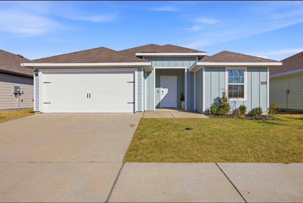 6535 Sand Dune Way, Princeton, TX 75407 Single-story exterior featuring board-and-batten siding, a covered entryway, a concrete driveway, and an attached two-car garage