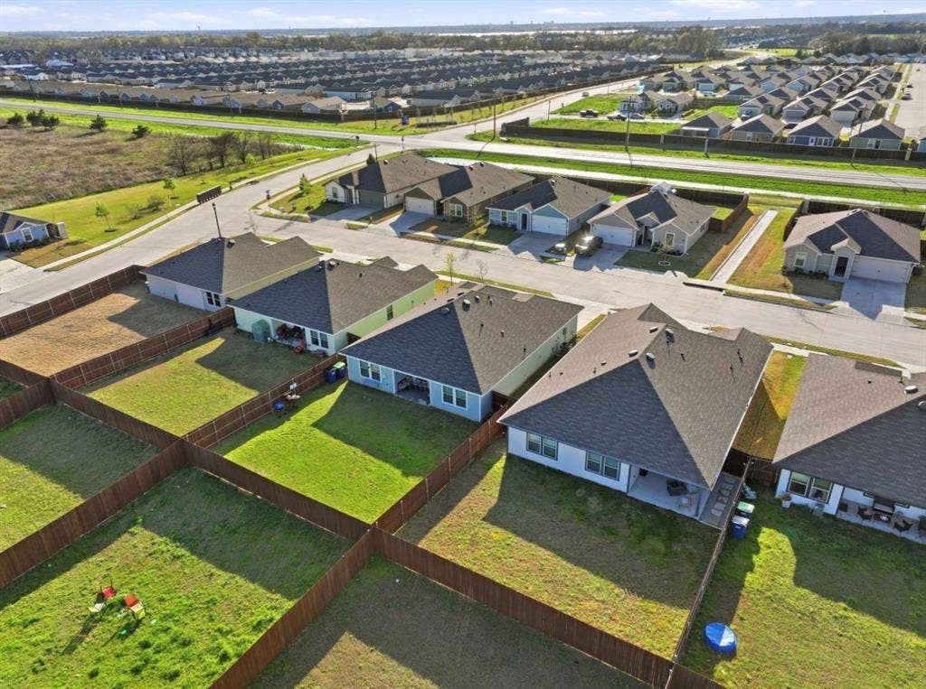 6535 Sand Dune Way, Princeton, TX 75407 Aerial perspective of a residential property featuring a fenced backyard, a rear covered patio, and a shingle roof